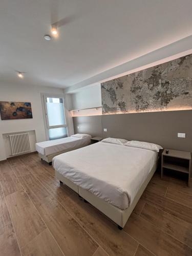 a bedroom with two beds and a painting on the wall at M14 Duomo Apartments in Padova