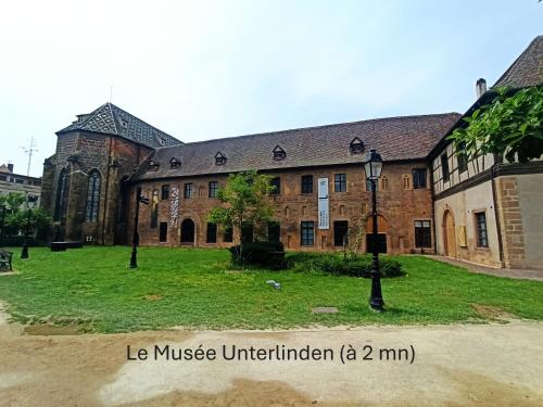 a large brick building with a street light in front of it at Chambre - Centre historique - Equipée - Salle d'eau et WC privés in Colmar