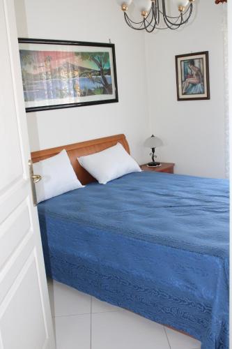 une chambre avec un lit avec un couvre-lit bleu dans l'établissement Le Must ! ADMIRAL PLAZA, à Menton