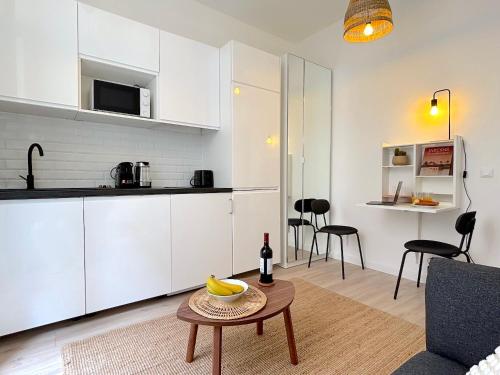 Il comprend une cuisine et un salon avec une table. dans l'établissement L'appartement Plaisance, à Paris