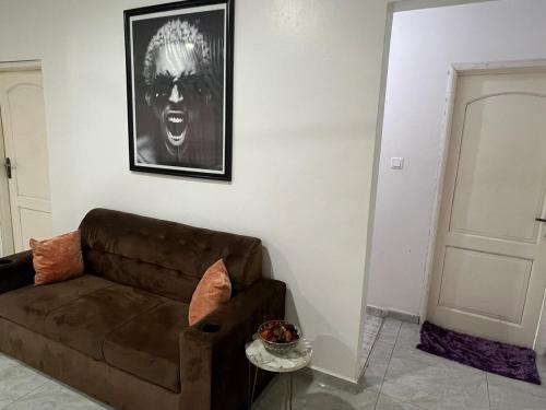 a living room with a brown couch and a picture at Lighthouse in Trofwi