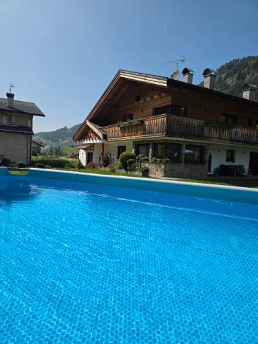 a large swimming pool in front of a house at Piciulei Pitl in Selva di Val Gardena