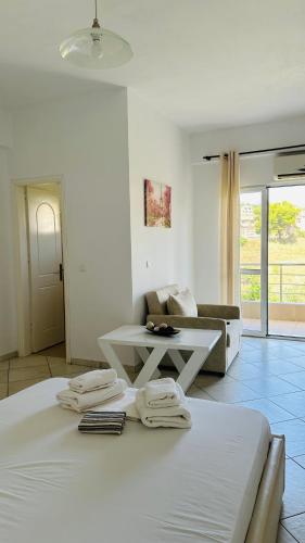 a white room with a white bed and a couch at Orea Hotel in Himare