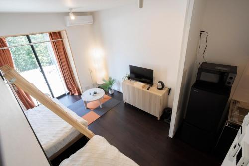 a living room with a bed and a tv at ハーモニーヒルズVilla箱根強羅 in Hakone