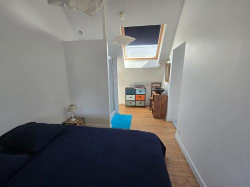 - une chambre avec un lit bleu et un couloir dans l'établissement Maison les pieds dans l'eau - Vue exceptionnelle, à Groix