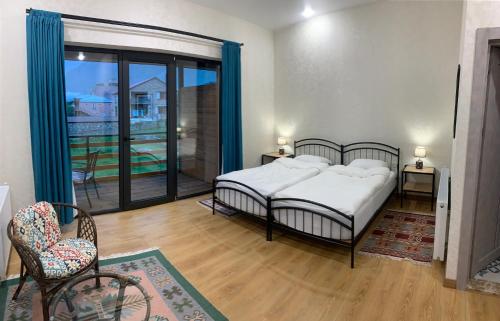 a bedroom with a bed and a large window at Mountain View in Stepantsminda