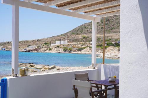 a table and chairs on a porch with a view of the ocean at Apleton Beach House Kimolos at Zacharias Beach in Kimolos