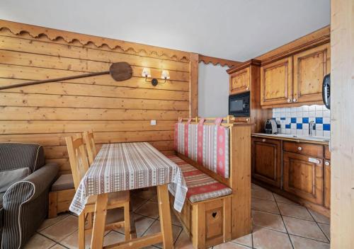 une petite cuisine avec une table et une cuisine gmaxwell gmaxwell gmaxwell gmaxwell dans l'établissement Appartement Ecrin B112, à Tignes