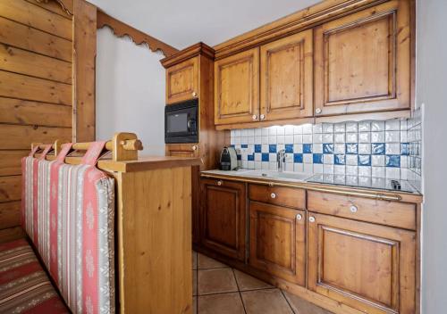 une cuisine avec des armoires en bois et un évier dans l'établissement Appartement Ecrin B112, à Tignes