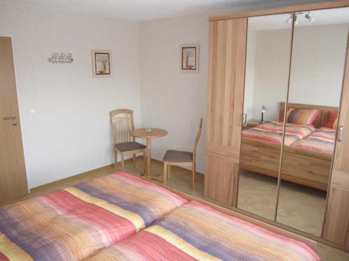 a hotel room with two beds and a table and a mirror at Ferienwohnung Schönhense in Medebach