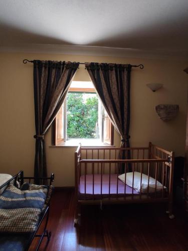 a bedroom with a crib in front of a window at 2Br Serra da Estrela Escape-Cheese & Wine Parking in Celorico da Beira