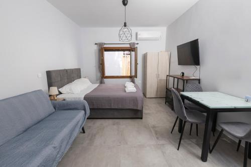 a living room with a couch and a bed and a table at Utopia suites 3 in the heart of Aegina by 8essentially in Aegina Town