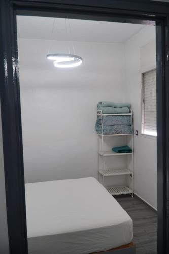 a bedroom with a white bed and a closet at Le Calme a Temara in Temara