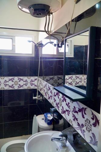 a bathroom with a sink and a mirror and a toilet at Le Calme a Temara in Temara