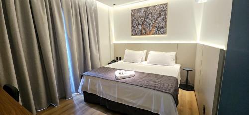 a small bedroom with a bed with white sheets at Blue Inn Hotel in Boa Vista