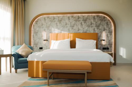 1 dormitorio con 1 cama grande y 1 silla azul en Sheraton Khalidiya Hotel, en Abu Dabi