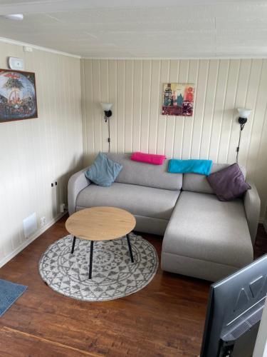 a living room with a couch and a table at Between fjord and mountain in Svolvær