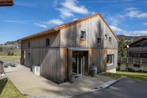 a large metal building with a garage at Chalet L'Urson, spacieux, jacuzzi, hammam et sauna in Gérardmer