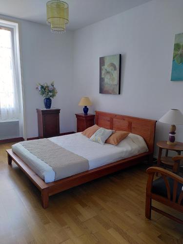 une chambre avec un grand lit dans une pièce dans l'établissement Maison du Centre, à Saint-Jean-de-Monts