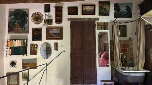 une pièce avec un mur rempli de tableaux et une porte dans l'établissement La Loube - Maison paysanne, à Buoux