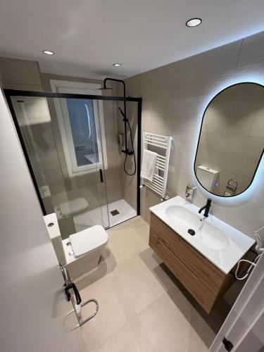 a bathroom with a toilet and a sink and a mirror at Plaza de España Burgos in Burgos