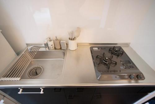 a kitchen with a sink and a stove at ハーモニーヒルズVilla箱根強羅 in Hakone