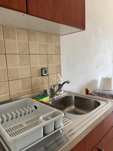 a kitchen with a sink and a stainless steel sink at Κaryatis studios lixouri in Lixouri
