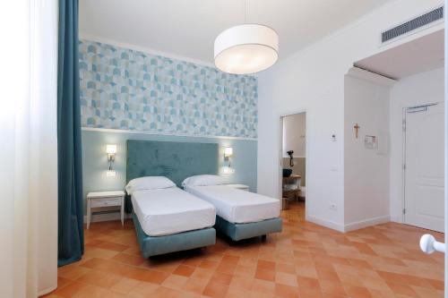 a bedroom with two beds and a blue wall at D'Amalfi Hospitality in Amalfi