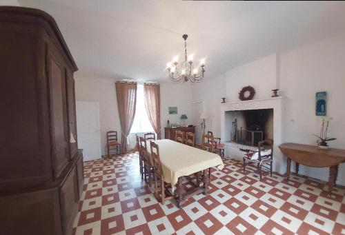 un salon avec une table et des chaises et une cheminée dans l'établissement Le Gîte Adelis, à La Celle-sous-Gouzon