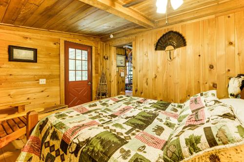 a bedroom with a bed in a wooden cabin at 35 Mi to Acadia Rustic Retreat in Orland! in Orland