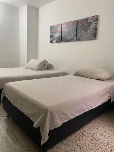 two beds sitting next to each other in a room at Hmetrohotel in Medellín