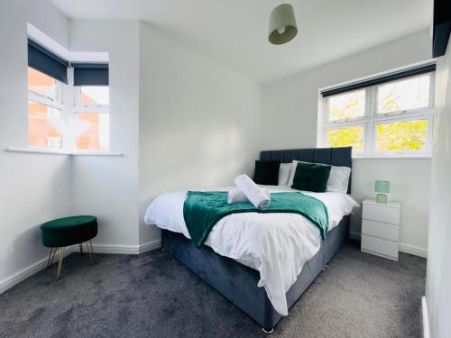 une chambre avec un grand lit et deux fenêtres dans l'établissement Sunderland City Centre Modern 2 Bed Apartment, à Sunderland