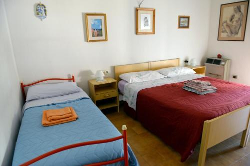 a bedroom with two beds and a night stand with a bedskirts at Appartamento Climatizzato con Piscina Ca' Aurelia in Lido di Savio
