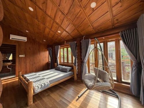 a bedroom with a swinging bed and a chair at Resort Suối Ngựa in Buôn Ké Blang
