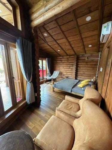 a bedroom with a bed and a couch in a room at Resort Suối Ngựa in Buôn Ké Blang