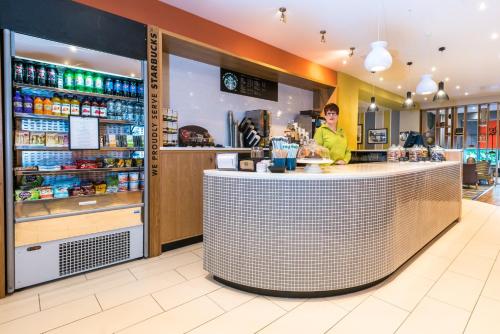 a man standing at a counter in a restaurant at Holiday Inn Rotherham-Sheffield M1,Jct.33 by IHG in Rotherham