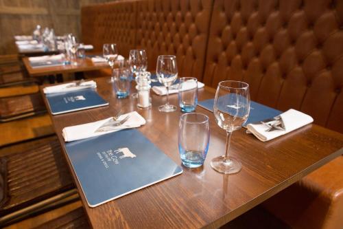 a table with wine glasses and a laptop on it at Holiday Inn Rotherham-Sheffield M1,Jct.33 by IHG in Rotherham