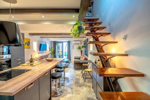 une cuisine avec des étagères en bois et un îlot de cuisine dans l'établissement Magnifique Maison de Village climatisée, terrasse, au Plan-de-la-Tour