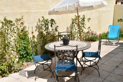 une table avec des chaises et un parasol sur une terrasse dans l'établissement Chambre chez l'habitant avec Piscine, à Bessan