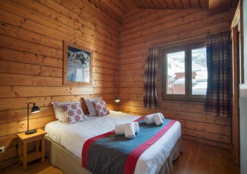 a bedroom with a bed in a log cabin at Appartement Ecrin 324 in Tignes