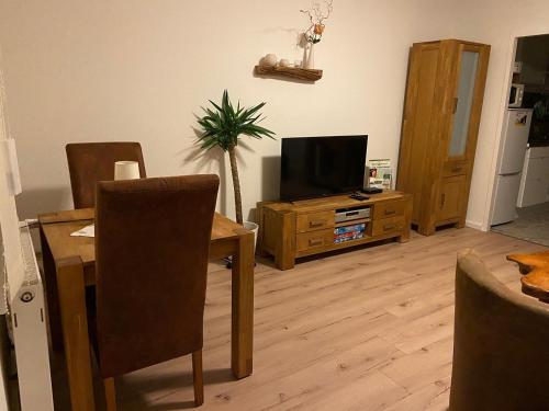 a living room with a table and a television at Apartment Seeidyll in Groß Köris
