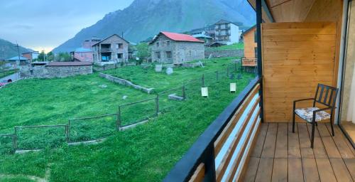 a balcony with a chair and a view of a field at Mountain View in Stepantsminda