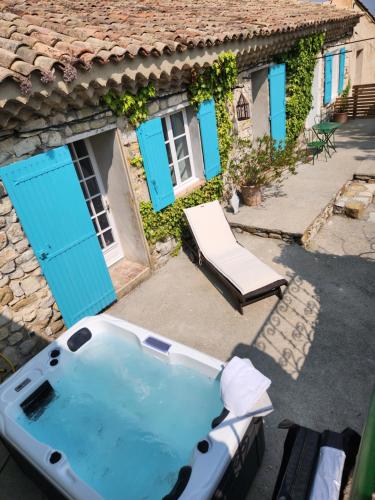 une baignoire devant une maison aux portes bleues dans l'établissement Les Bulles de Montfort - WiFi - Parking gratuit & Cuisine, à Montfort