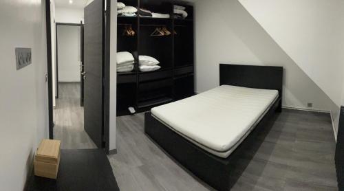 - une petite chambre avec un lit et un placard dans l'établissement Maison vert galand, à Villepinte