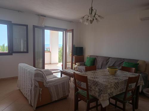 a living room with a table and a couch at San Teodoro Graziosa casa vacanza con parcheggio privato in San Teodoro