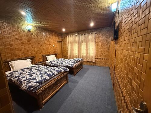 SkarduSummit guest house skardu的一间房间里有两张床，其中有两张可操作的床