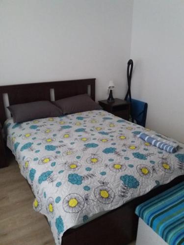 a bed with a quilt with flowers on it at Sun Holidays Byala in Byala