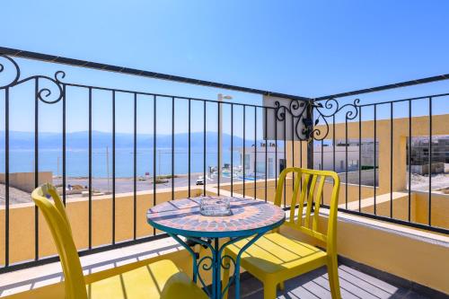 a table and chairs on a balcony with a view of the ocean at הבית מול הים in Neve Zohar