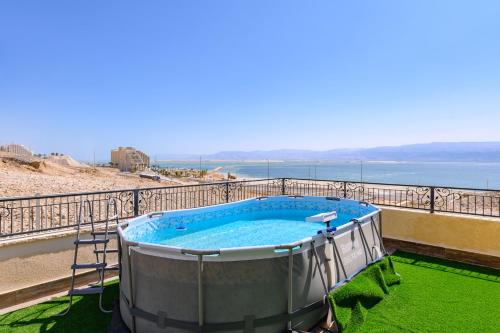 a hot tub on a balcony next to the beach at הבית מול הים in Neve Zohar