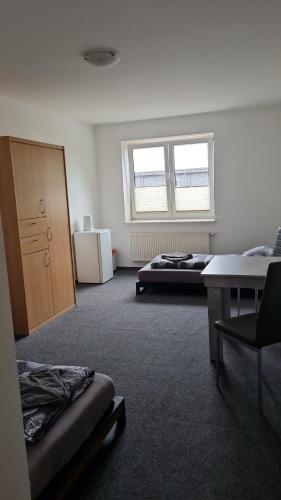 a room with two beds and a desk and a window at Zweibettzimmer mit eigenem Bad in Rostock